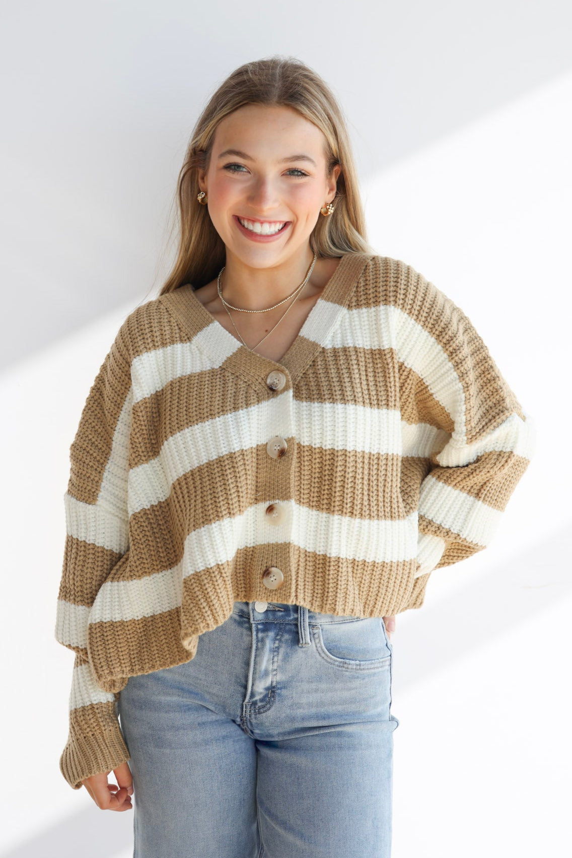 Woman wearing a striped sweater and jeans on a white background
