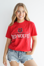 Person wearing a red 'Red Wolves' t-shirt with denim shorts on a white background