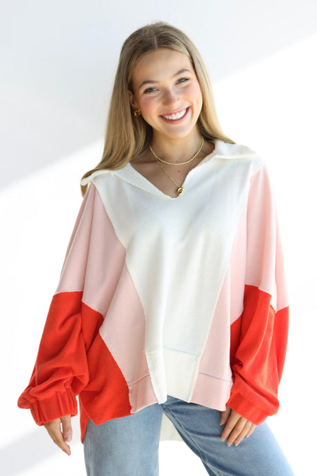 Woman wearing a colorful shirt with red, pink, and white sleeves on a white background