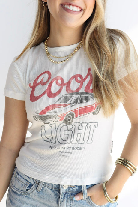 Woman wearing a white t-shirt with red and black graphics on a plain background