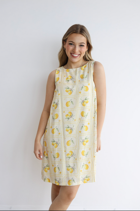 Woman wearing a lemon-patterned dress against a white background
