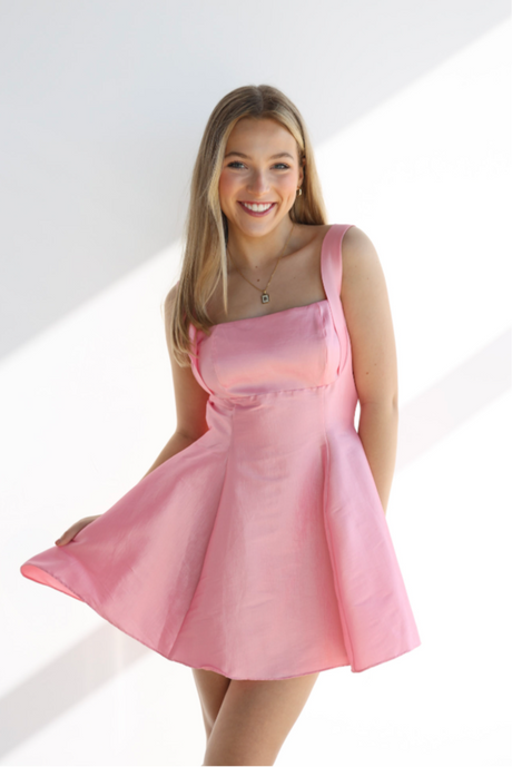 Woman wearing a pink dress against a white background