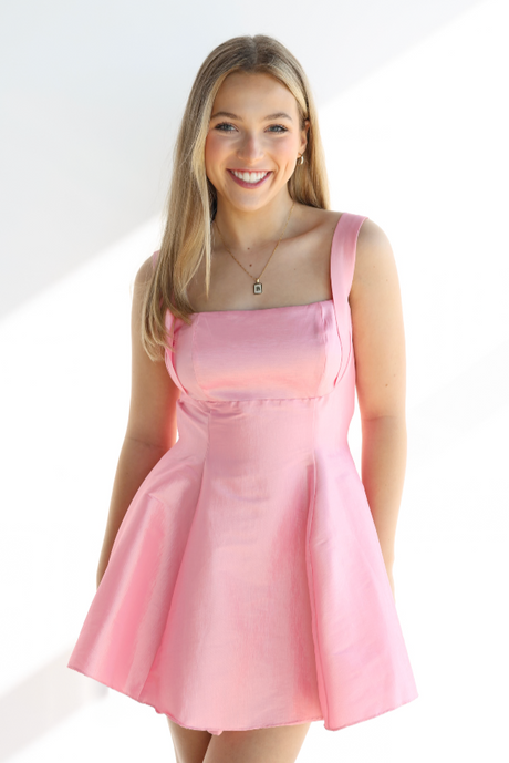 Woman wearing a pink dress against a white background