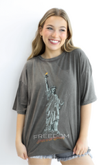 Woman wearing a gray t-shirt with a graphic design of the Statue of Liberty and the word 'Freedom'.