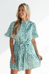 Woman wearing a green floral dress on a white background