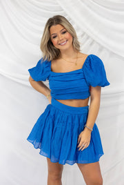 BUDDY LOVE CUTIE SKIRT AND TOP WITH A PUFF SLEEVE AND SOFT PLEAT SKIRT. LAYERING AROUND BUST. AVAILABLE IN BLUE AND PINK.